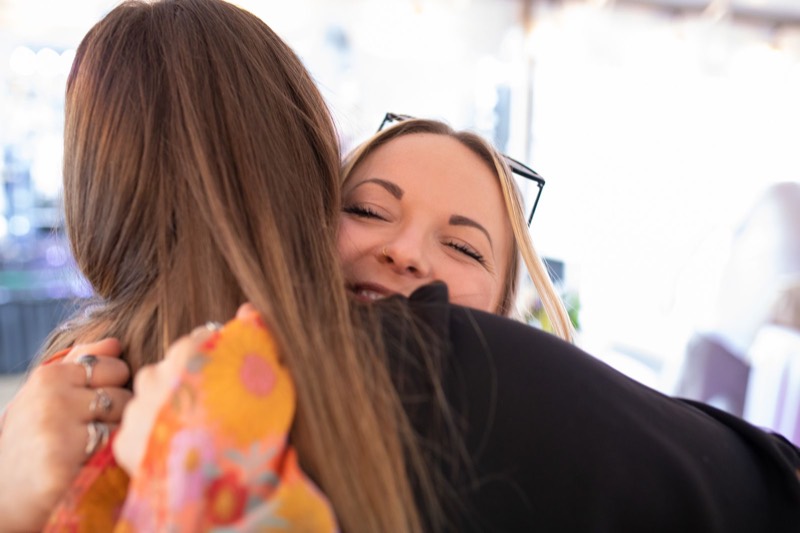 Two Gravity agents sharing a hug at a company event
